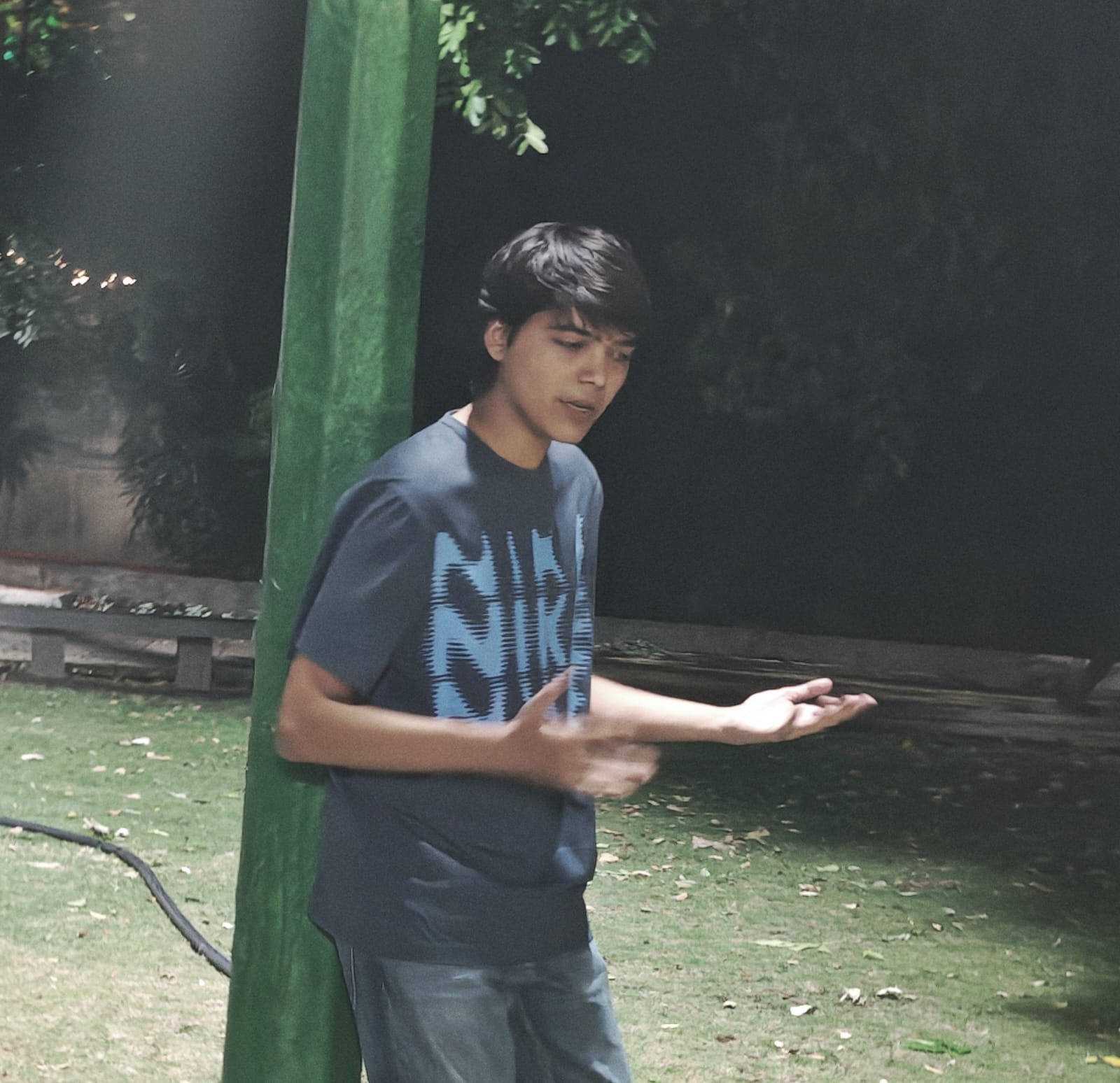 Chaitanya standing on a grass court at night