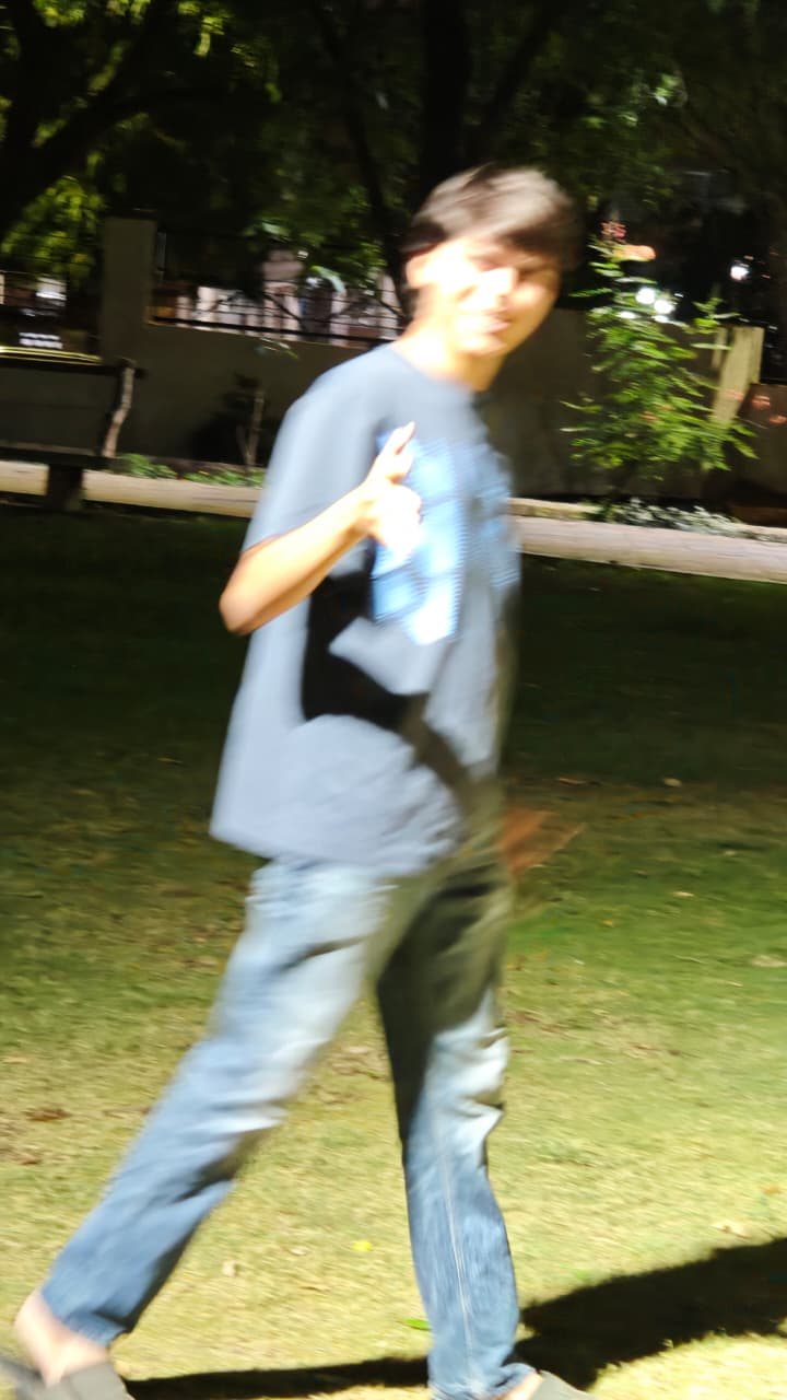 Chaitanya walking through a lit grass field